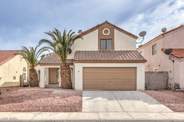 mediterranean / spanish home featuring concrete driveway, fence, a tiled roof, and stucco siding