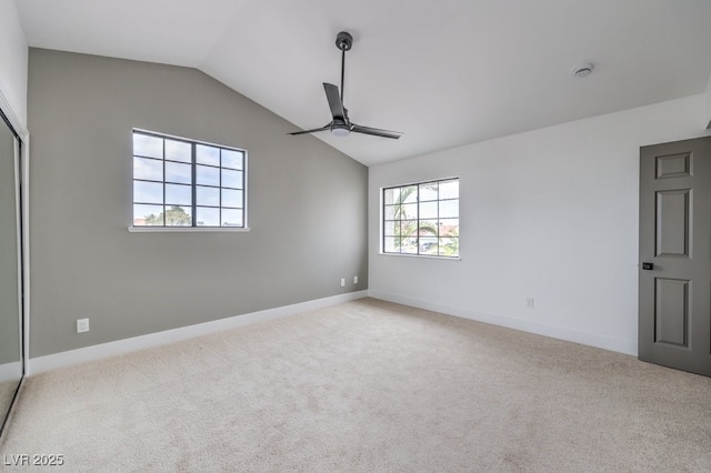 unfurnished room featuring carpet floors, baseboards, a ceiling fan, and lofted ceiling