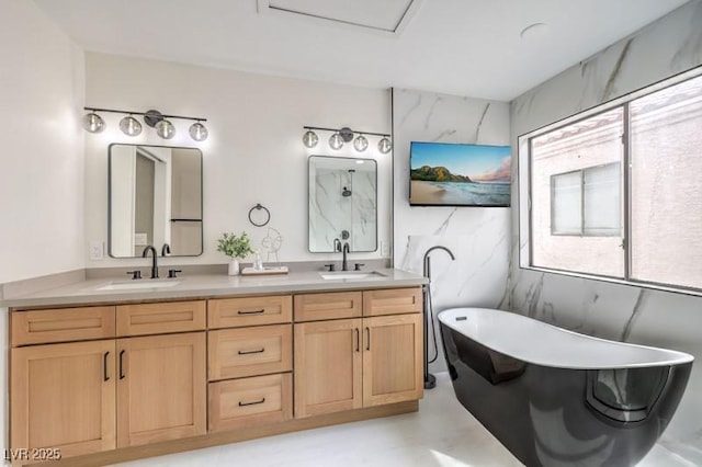 bathroom featuring double vanity, a soaking tub, and a sink