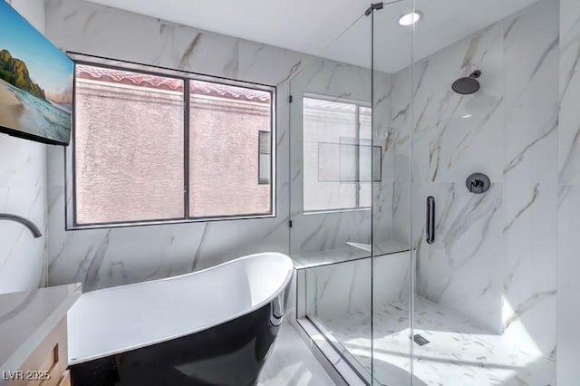 bathroom featuring a freestanding tub, a marble finish shower, and vanity