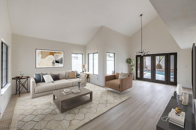 living area featuring high vaulted ceiling, french doors, and light wood-style flooring