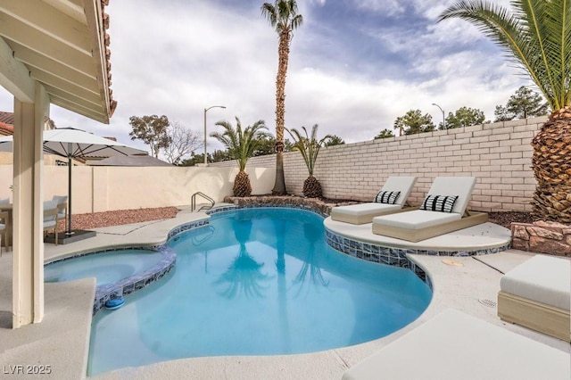 view of pool with a fenced backyard and a pool with connected hot tub