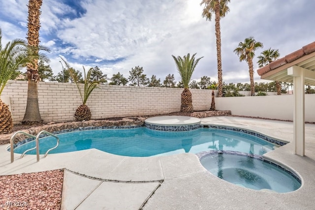 view of pool with a fenced backyard and a pool with connected hot tub