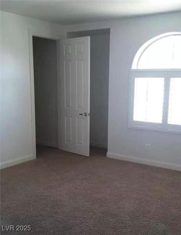 carpeted spare room with baseboards