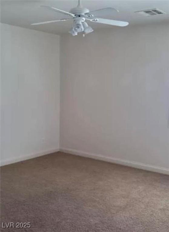 spare room featuring carpet flooring, ceiling fan, visible vents, and baseboards