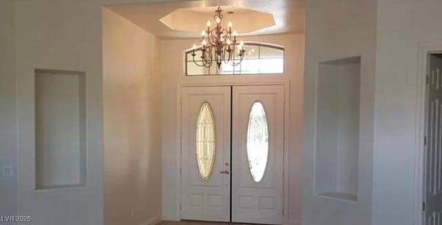 foyer featuring a chandelier and french doors