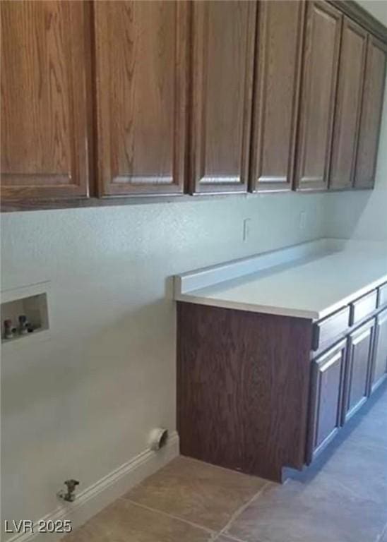 laundry area with hookup for a washing machine, cabinet space, and baseboards