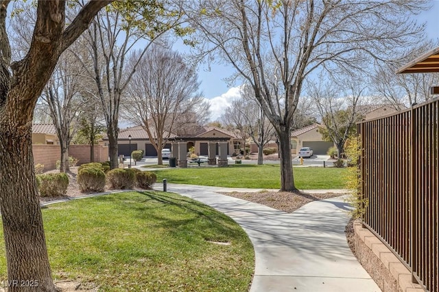 view of property's community with a yard and fence