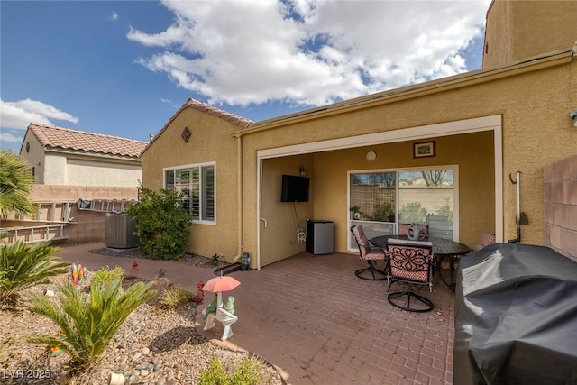 back of property featuring stucco siding, central AC, and fence