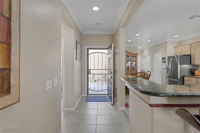 kitchen featuring light tile patterned floors, light brown cabinetry, ornamental molding, and stainless steel fridge with ice dispenser