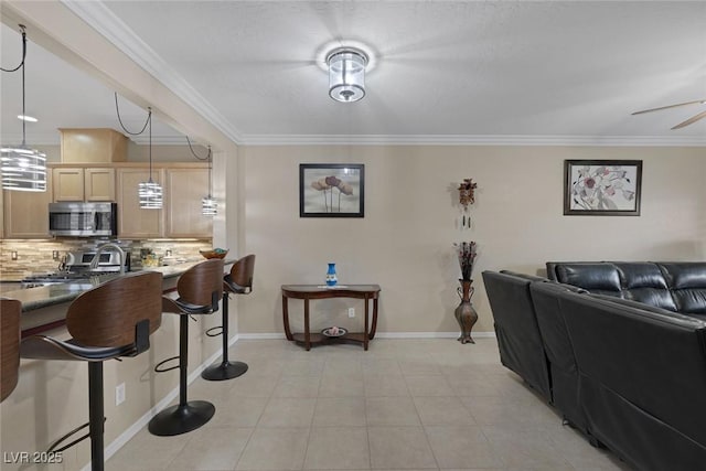 living room with light tile patterned flooring, crown molding, and baseboards