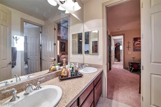 ensuite bathroom featuring ensuite bathroom, double vanity, tile patterned flooring, and a sink