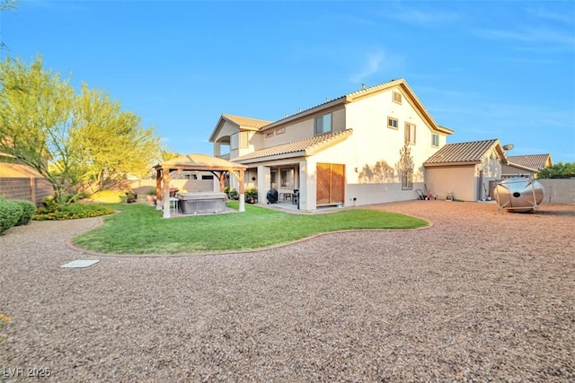 rear view of property with a hot tub, a gazebo, a patio area, a fenced backyard, and a tiled roof