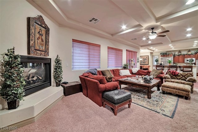 carpeted living area featuring recessed lighting, coffered ceiling, a multi sided fireplace, visible vents, and a ceiling fan