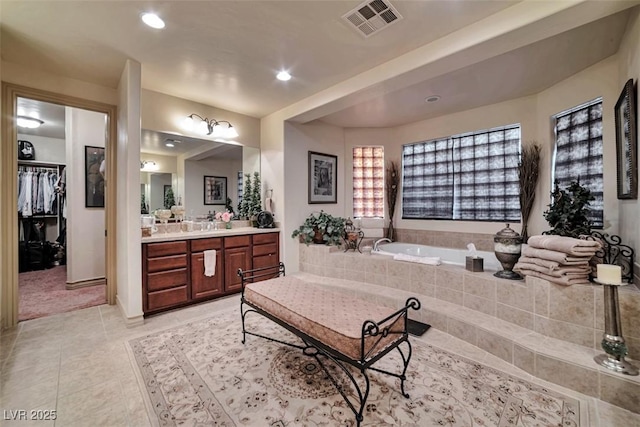 bathroom featuring visible vents, tile patterned flooring, a spacious closet, vanity, and a bath