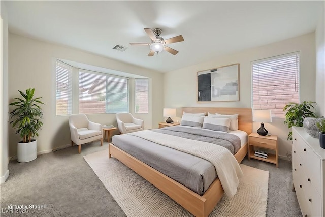 carpeted bedroom with visible vents, ceiling fan, and baseboards