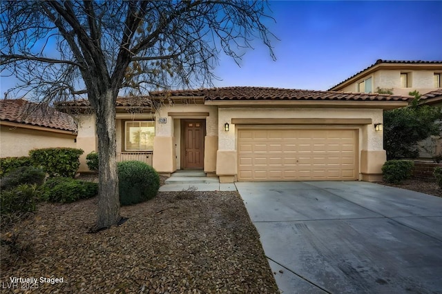 view of front of home with driveway, an attached garage, a tiled roof, and stucco siding