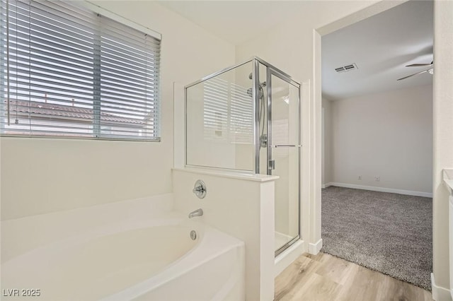 full bath with a garden tub, visible vents, a ceiling fan, a stall shower, and wood finished floors