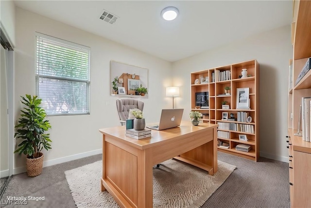 office featuring visible vents, light carpet, and baseboards