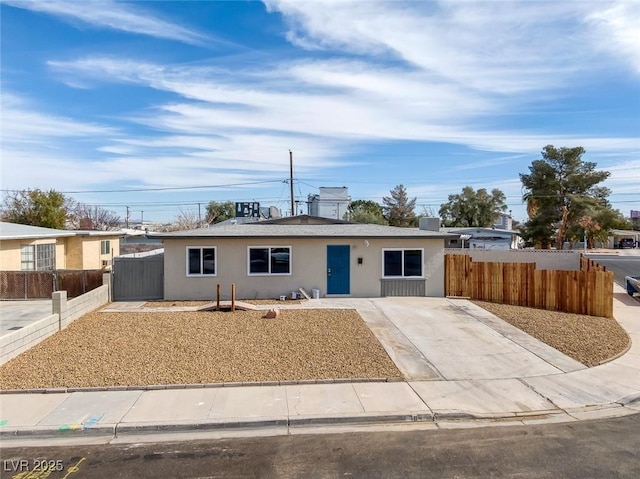 ranch-style home featuring fence and stucco siding