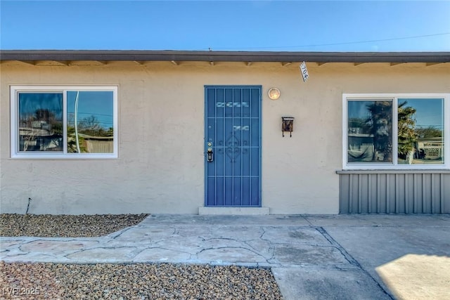 view of exterior entry featuring stucco siding