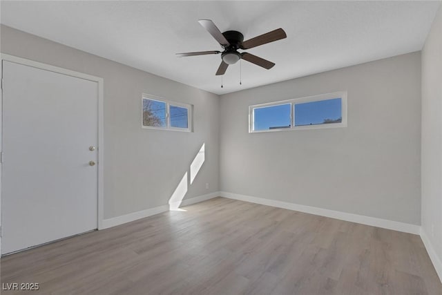 spare room with ceiling fan, baseboards, and wood finished floors