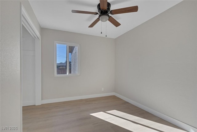 empty room featuring ceiling fan, baseboards, and wood finished floors