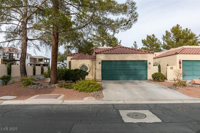 mediterranean / spanish home with an attached garage, a tiled roof, concrete driveway, and stucco siding