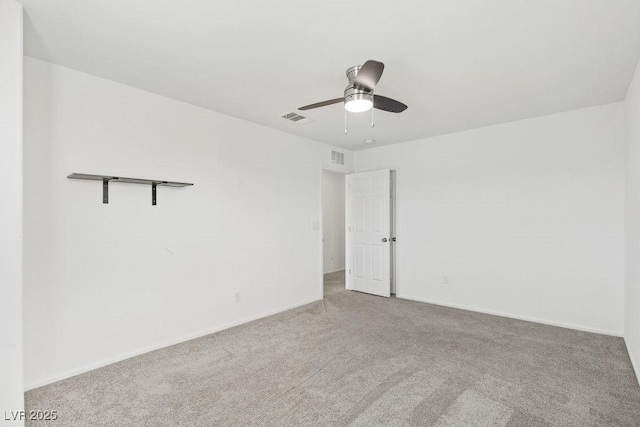 carpeted spare room with baseboards, visible vents, and a ceiling fan