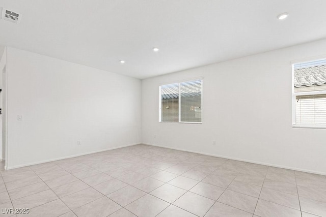 empty room featuring baseboards, plenty of natural light, visible vents, and recessed lighting