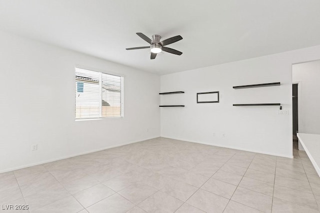 empty room with a ceiling fan and baseboards