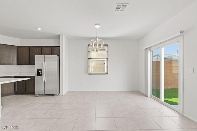 kitchen featuring a notable chandelier, visible vents, dark brown cabinets, light countertops, and stainless steel refrigerator with ice dispenser