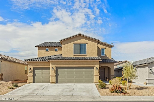 mediterranean / spanish-style home with a garage, driveway, a tile roof, and stucco siding