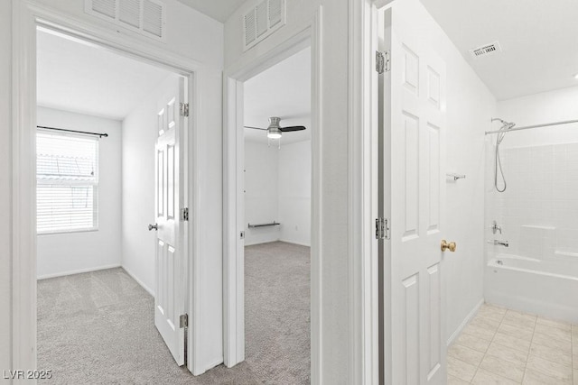 bathroom featuring bathing tub / shower combination, visible vents, and baseboards