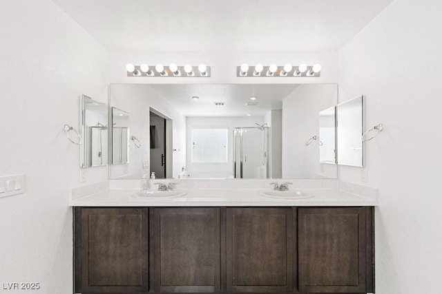 bathroom with double vanity, a sink, and a shower stall