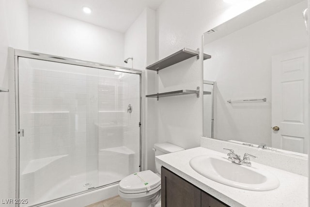 bathroom featuring toilet, a stall shower, and vanity