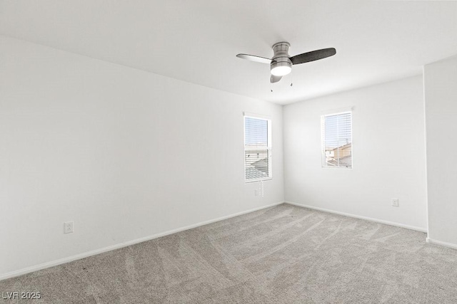 empty room with a ceiling fan, light colored carpet, and baseboards