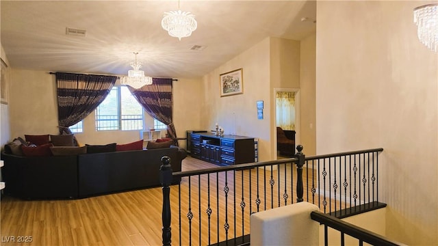 interior space with visible vents, a chandelier, and wood finished floors