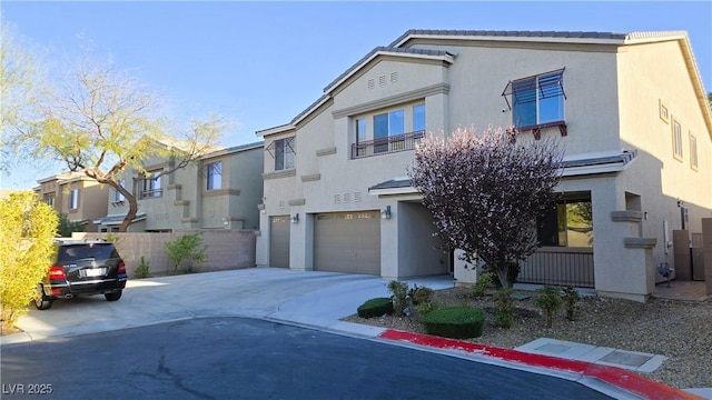 view of front of home featuring driveway, an attached garage, and stucco siding