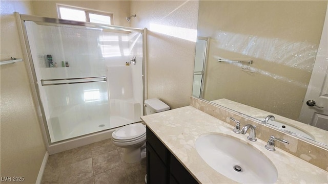 bathroom with toilet, a shower stall, vanity, and tile patterned floors