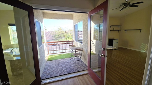 doorway with a ceiling fan, french doors, baseboards, and wood finished floors