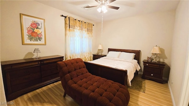 bedroom with ceiling fan, wood finished floors, and baseboards