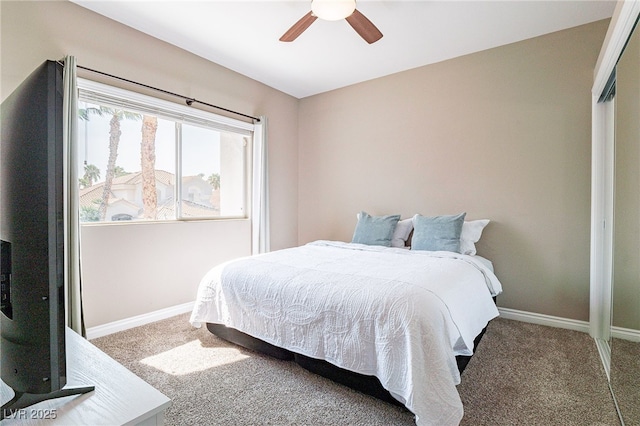 carpeted bedroom featuring baseboards and a ceiling fan