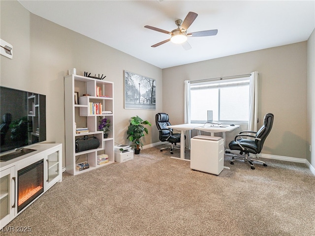 office with carpet, baseboards, a ceiling fan, and a glass covered fireplace