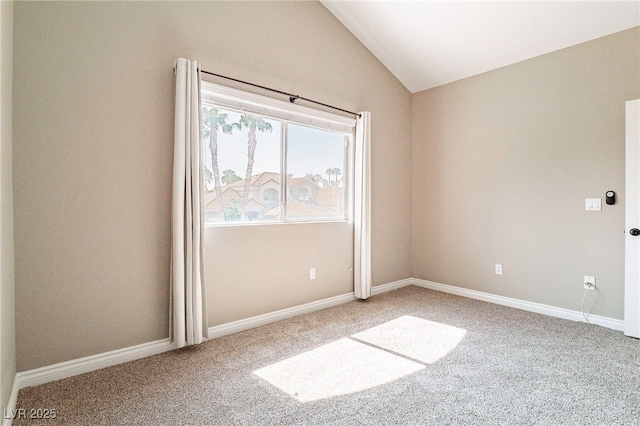 carpeted spare room with lofted ceiling and baseboards