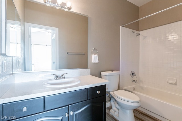 full bath with tub / shower combination, vanity, toilet, and wood finished floors