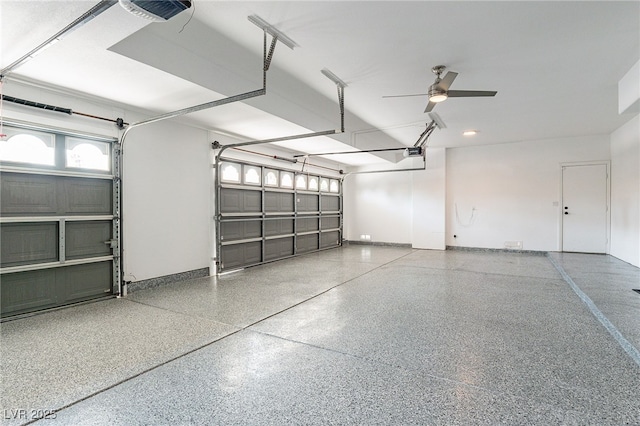 garage featuring a garage door opener, ceiling fan, and baseboards