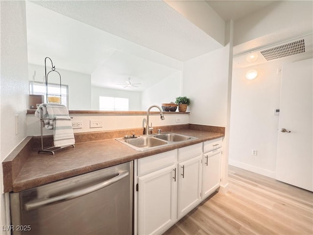 kitchen featuring light wood-style flooring, stainless steel dishwasher, a ceiling fan, white cabinetry, and a sink