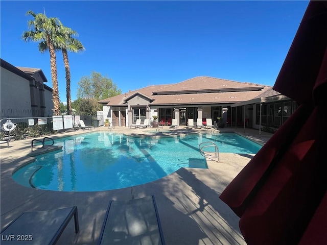 community pool with a patio and fence