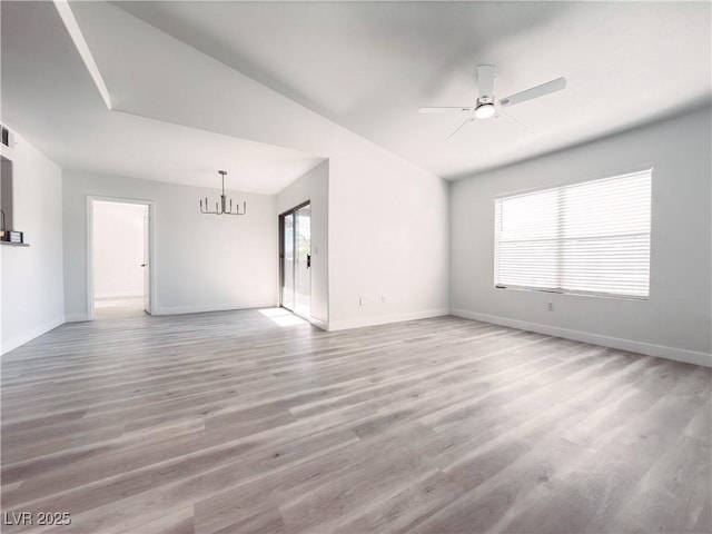 unfurnished living room with light wood-type flooring, plenty of natural light, baseboards, and ceiling fan with notable chandelier